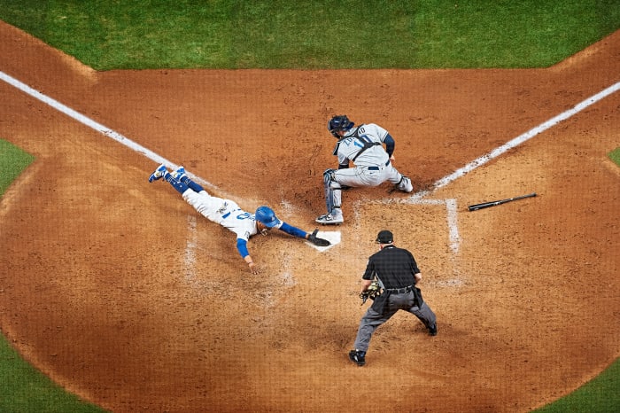 Dodgers’ Mookie Betts slides headfirst into home plate ahead of a tag from Rays catcher Mike Zunino during the 2020 World Series